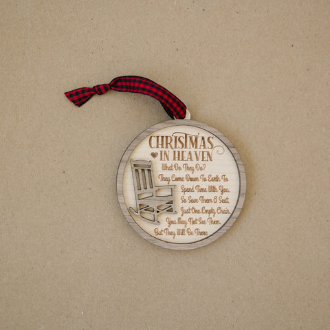 Officially licensed Christmas in Heaven memorial wooden ornament by John F Connor, featuring a poignant chair design with the iconic 'Christmas in Heaven' poem. A heartfelt remembrance gift for the holiday season, this maple and walnut ornament can be personalized on the back with any name or phrase. Versatile for use as a tree ornament or a year-round display, it serves as a touching sympathy gift, preserving cherished memories with enduring grace.