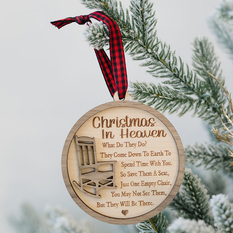 Officially licensed Christmas in Heaven memorial wooden ornament by John F Connor, featuring a poignant chair design with the iconic 'Christmas in Heaven' poem. A heartfelt remembrance gift for the holiday season, this maple and walnut ornament can be personalized on the back with any name or phrase. Versatile for use as a tree ornament or a year-round display, it serves as a touching sympathy gift, preserving cherished memories with enduring grace.