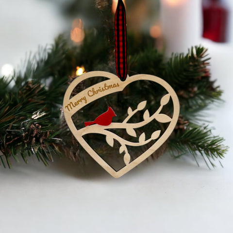 A wooden heart-shaped ornament adorned with intricate carvings. The words 'Merry Christmas' are elegantly engraved across the top of the heart. This memorial ornament captures the spirit of Christmas with its heartfelt design.