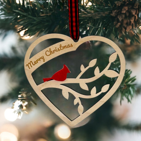A wooden heart-shaped ornament adorned with intricate carvings. The words 'Merry Christmas' are elegantly engraved across the top of the heart. This memorial ornament captures the spirit of Christmas with its heartfelt design.