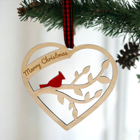 A wooden heart-shaped ornament adorned with intricate carvings. The words 'Merry Christmas' are elegantly engraved across the top of the heart. This memorial ornament captures the spirit of Christmas with its heartfelt design.
