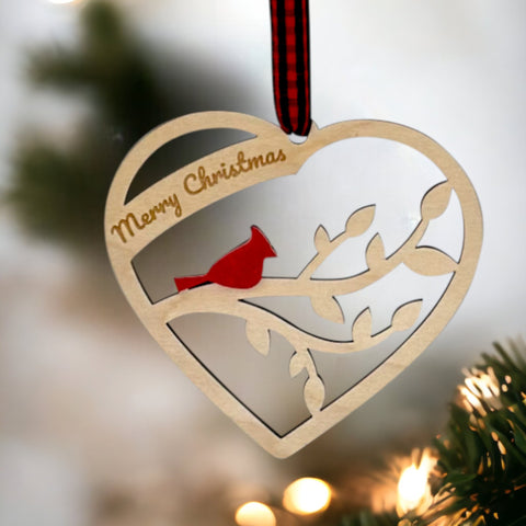 A wooden heart-shaped ornament adorned with intricate carvings. The words 'Merry Christmas' are elegantly engraved across the top of the heart. This memorial ornament captures the spirit of Christmas with its heartfelt design.