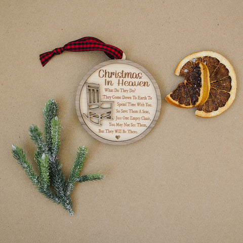 Officially licensed Christmas in Heaven memorial wooden ornament by John F Connor, featuring a poignant chair design with the iconic 'Christmas in Heaven' poem. A heartfelt remembrance gift for the holiday season, this maple and walnut ornament can be personalized on the back with any name or phrase. Versatile for use as a tree ornament or a year-round display, it serves as a touching sympathy gift, preserving cherished memories with enduring grace.