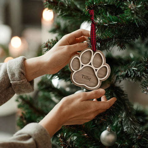 Adorable Personalized Dog Paw Ornament - Cherish your furry friend with this customized ornament featuring a cute paw print. Add your dog's name for a truly special keepsake, perfect for celebrating the joy your pet brings to your holiday season.