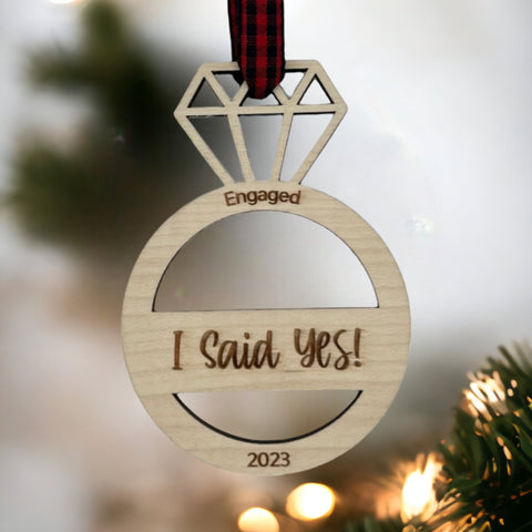 I Said Yes Engaged Ornament - Commemorate the joyous occasion with this charming ornament, symbolizing the beginning of a beautiful journey together. Adorn your tree with this special keepsake, celebrating the excitement of your engagement during the holiday season.