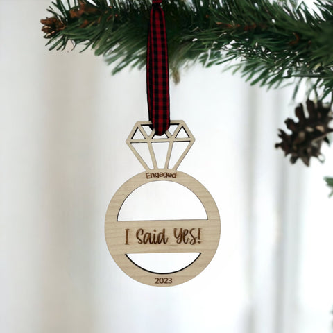 I Said Yes Engaged Ornament - Commemorate the joyous occasion with this charming ornament, symbolizing the beginning of a beautiful journey together. Adorn your tree with this special keepsake, celebrating the excitement of your engagement during the holiday season.