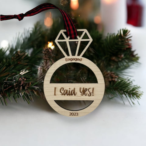 I Said Yes Engaged Ornament - Commemorate the joyous occasion with this charming ornament, symbolizing the beginning of a beautiful journey together. Adorn your tree with this special keepsake, celebrating the excitement of your engagement during the holiday season.