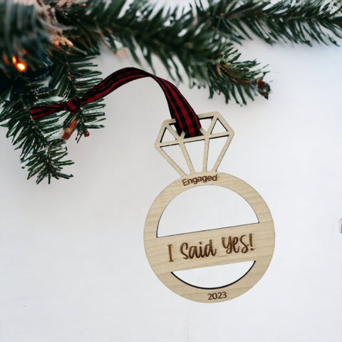 I Said Yes Engaged Ornament - Commemorate the joyous occasion with this charming ornament, symbolizing the beginning of a beautiful journey together. Adorn your tree with this special keepsake, celebrating the excitement of your engagement during the holiday season.