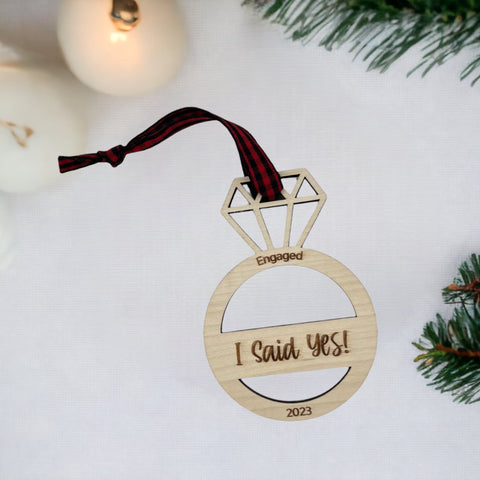 I Said Yes Engaged Ornament - Commemorate the joyous occasion with this charming ornament, symbolizing the beginning of a beautiful journey together. Adorn your tree with this special keepsake, celebrating the excitement of your engagement during the holiday season.