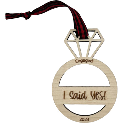 I Said Yes Engaged Ornament - Commemorate the joyous occasion with this charming ornament, symbolizing the beginning of a beautiful journey together. Adorn your tree with this special keepsake, celebrating the excitement of your engagement during the holiday season.