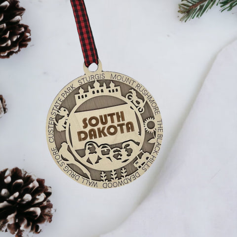 Bring the beauty of the Black Hills to your tree! Introducing the South Dakota State Highlights Ornament—a small treasure celebrating the spirit of the Mount Rushmore State. Elevate your holiday decor with a touch of South Dakota's natural wonders. Make your season merrier with a piece of the Midwest!